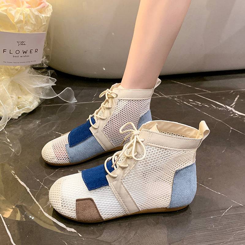 Model wearing high-top mesh booties with color-block design in beige, blue, and brown, laced up