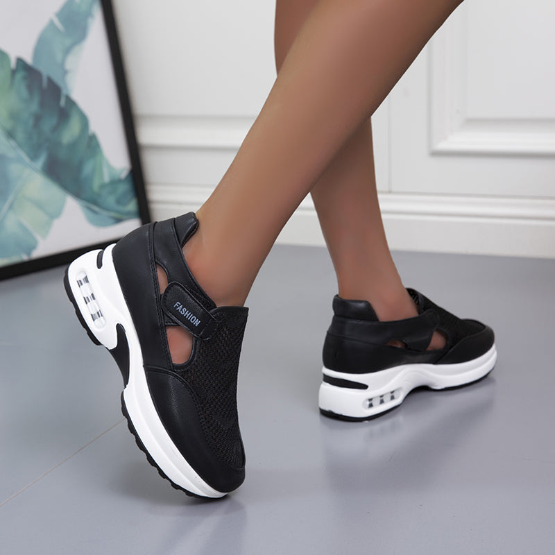 Model wearing black mesh fashion sneakers with a modern design