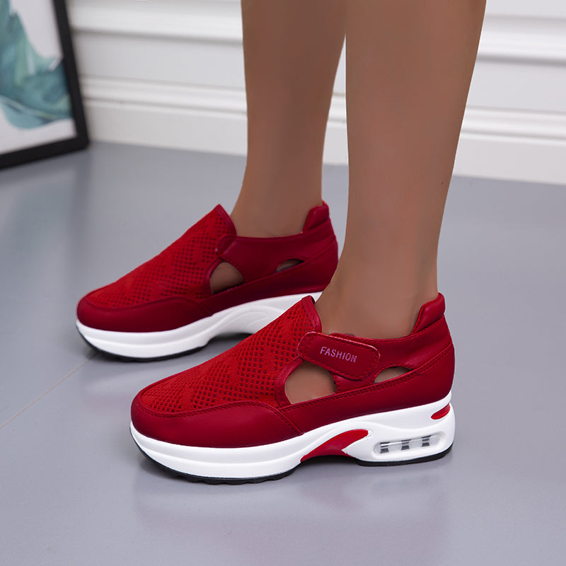 Model wearing red mesh fashion sneakers with a modern design